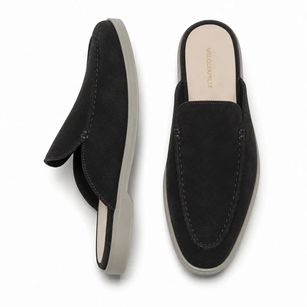 Black suede backless mule loafer, three-quarter angle showing heel and sole detailing