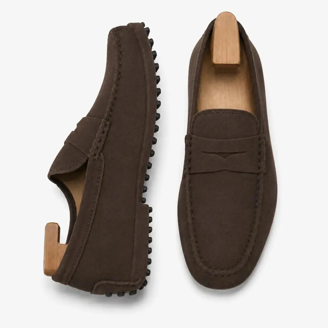 Dark brown suede penny loafer, three-quarter angle showing sole detailing