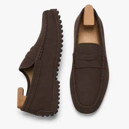 Dark brown suede penny loafer, three-quarter angle showing sole detailing