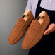 Man holding a pair of Melodiapelle Maryland Loafers in rust tan suede, close-up