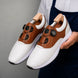 Man holding a pair of Melodiapelle Marzano BOA Golf Shoes in white and tan leather, close-up