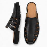 Black leather caged mule, three-quarter angle showing cutout panel and sole detailing