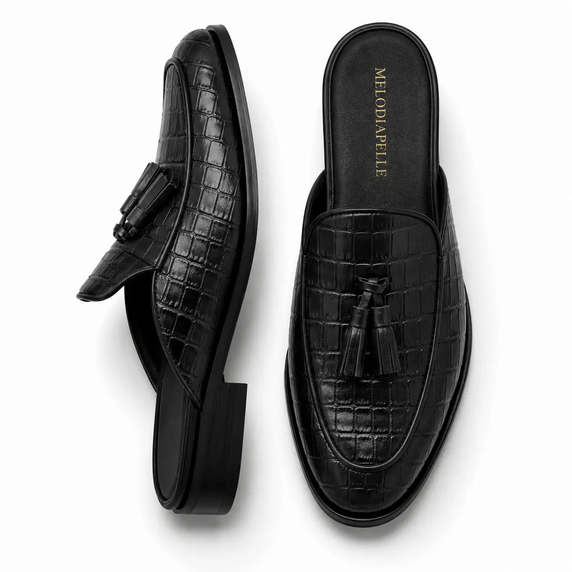Black croc-embossed leather tassel mule, three-quarter angle showing tassel and heel