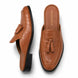 Tan croc-embossed leather tassel mule, three-quarter angle showing tassel and heel
