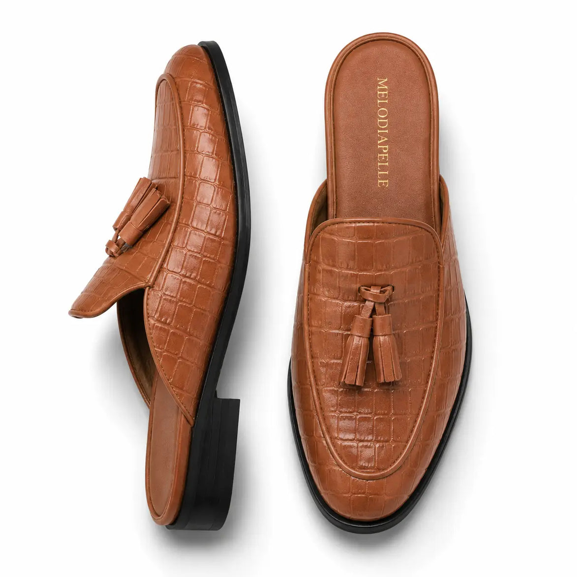Tan croc-embossed leather tassel mule, three-quarter angle showing tassel and heel