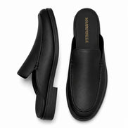 Black leather backless mule loafer, three-quarter angle showing heel and sole detailing