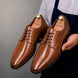 Man holding a pair of Melodiapelle Matera Plain-Toe Derby shoes in tan leather, close-up