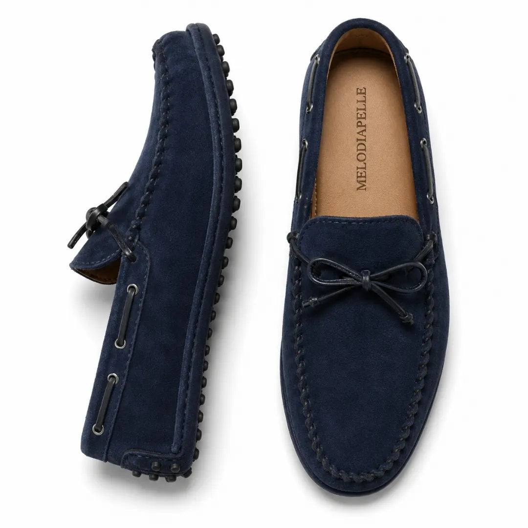 Navy blue suede driving loafer with bow lace, three-quarter angle showing sole detailing