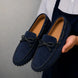 Man holding a pair of Melodiapelle Mathews Loafers in navy blue suede, close-up