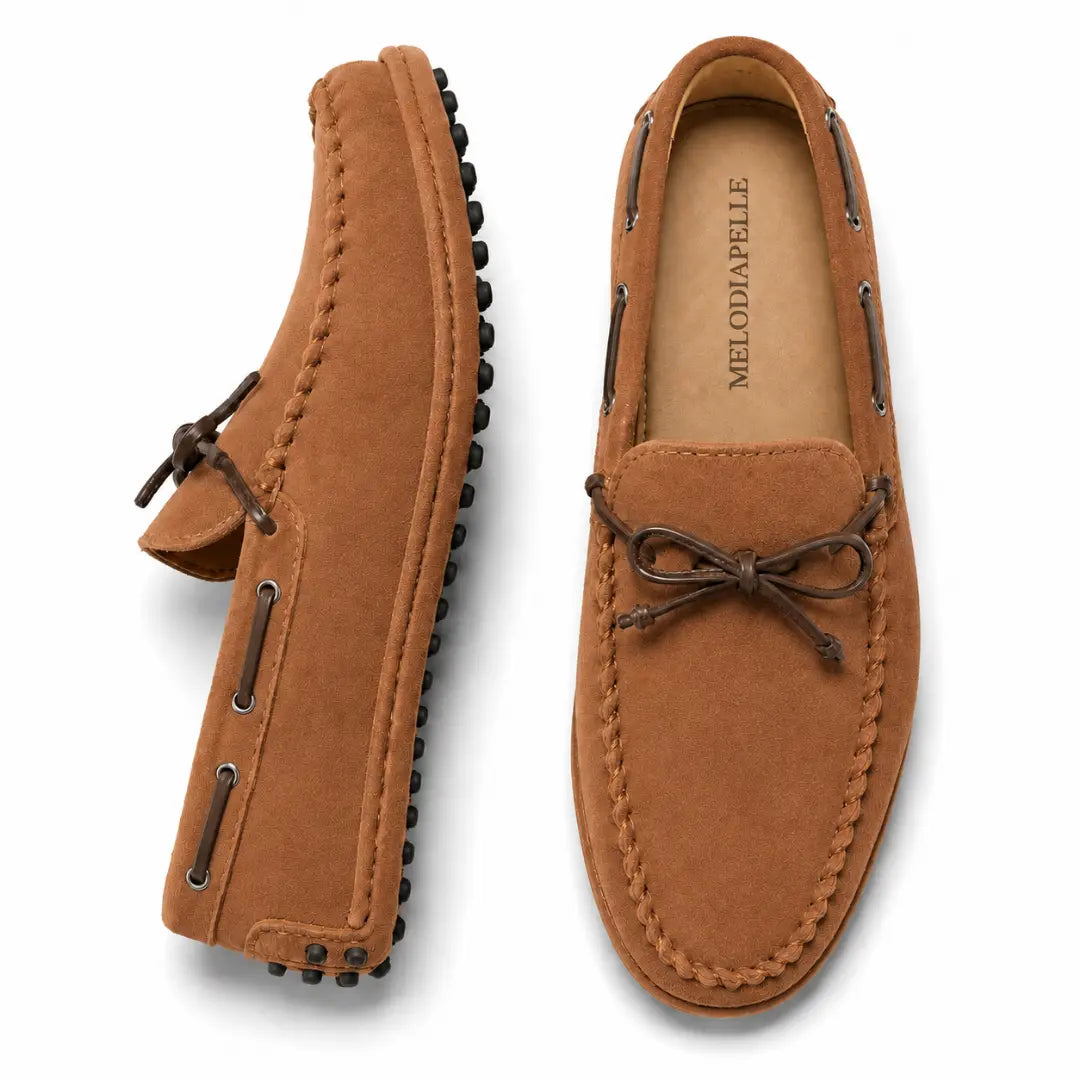 Rust tan suede driving loafer with bow lace, three-quarter angle showing sole detailing