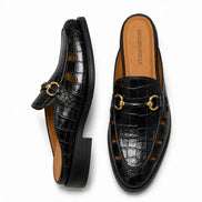 Black croc-embossed leather horsebit mule, three-quarter angle showing buckle and heel