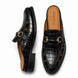 Black croc-embossed leather horsebit mule, three-quarter angle showing buckle and heel