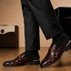 Melodiapelle Matilda Mule in oxblood brown croc-embossed leather worn with trousers, on-feet shot