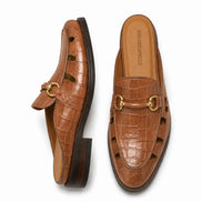 Tan croc-embossed leather horsebit mule, three-quarter angle showing buckle and heel