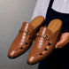 Man holding a pair of Melodiapelle Matilda Mule shoes in tan croc-embossed leather, close-up