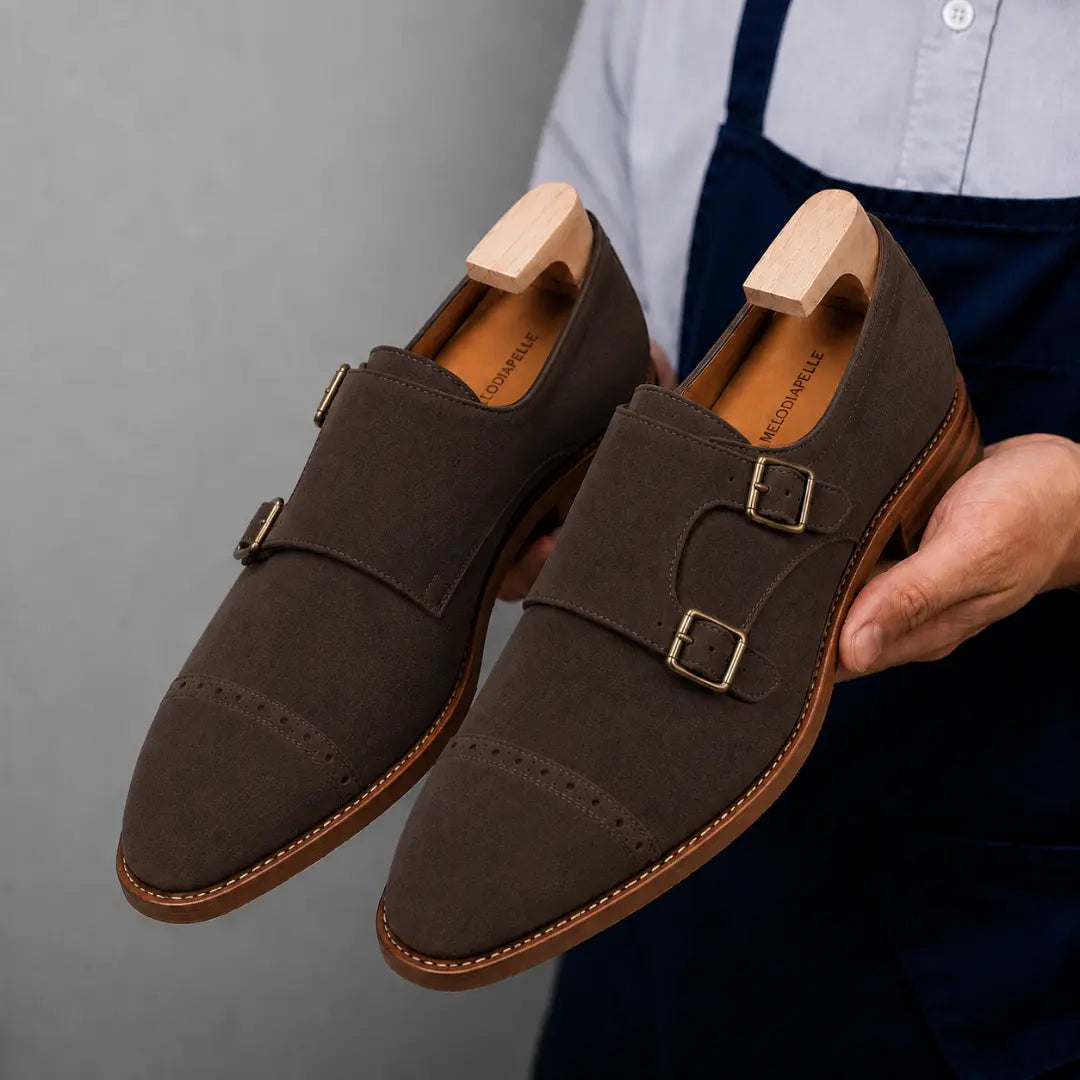 Man holding a pair of Melodiapelle Maverick Double Monk Brogue shoes in dark brown suede, close-up