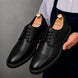 Man holding a pair of Melodiapelle Max Cap Toe Derby shoes in black leather, close-up