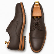 Dark brown leather cap-toe Derby, three-quarter angle showing heel and toe detailing