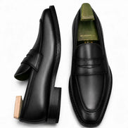 Black leather penny loafer, three-quarter angle showing heel and penny strap