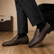 Melodiapelle Maximus Dress Penny Loafer in brown leather worn with formal trousers, on-feet shot