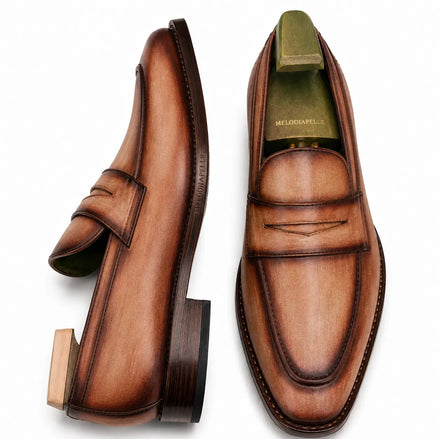 Cognac tan burnished leather penny loafer, three-quarter angle showing heel and penny strap