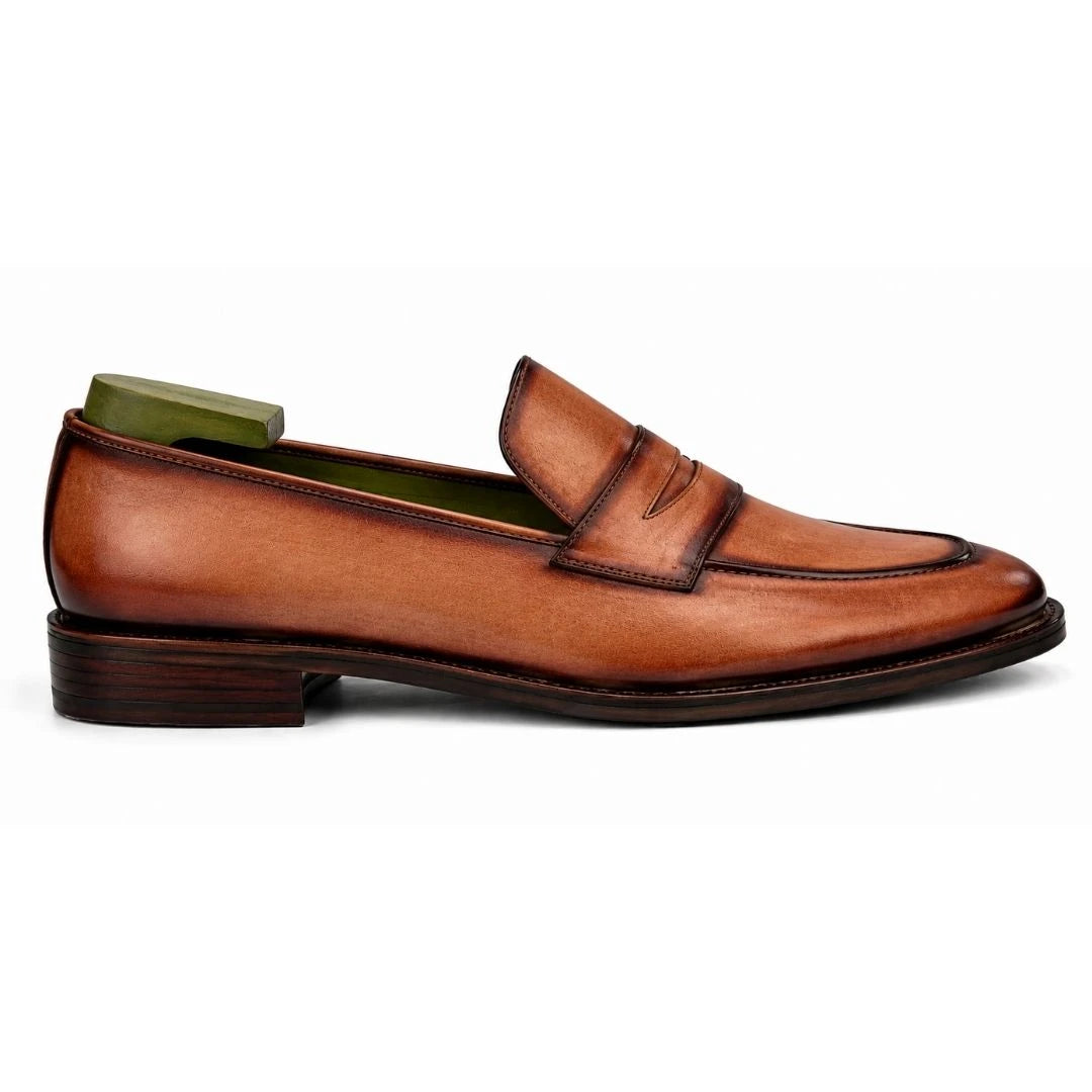 Side profile of the Maximus Dress Penny Loafer in cognac tan burnished leather on white background