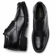Black leather cap-toe combat boot, three-quarter angle showing heel and sole detailing