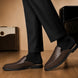 Melodiapelle Mckinsey Mule in dark brown croc-embossed leather worn with formal trousers, on-feet shot