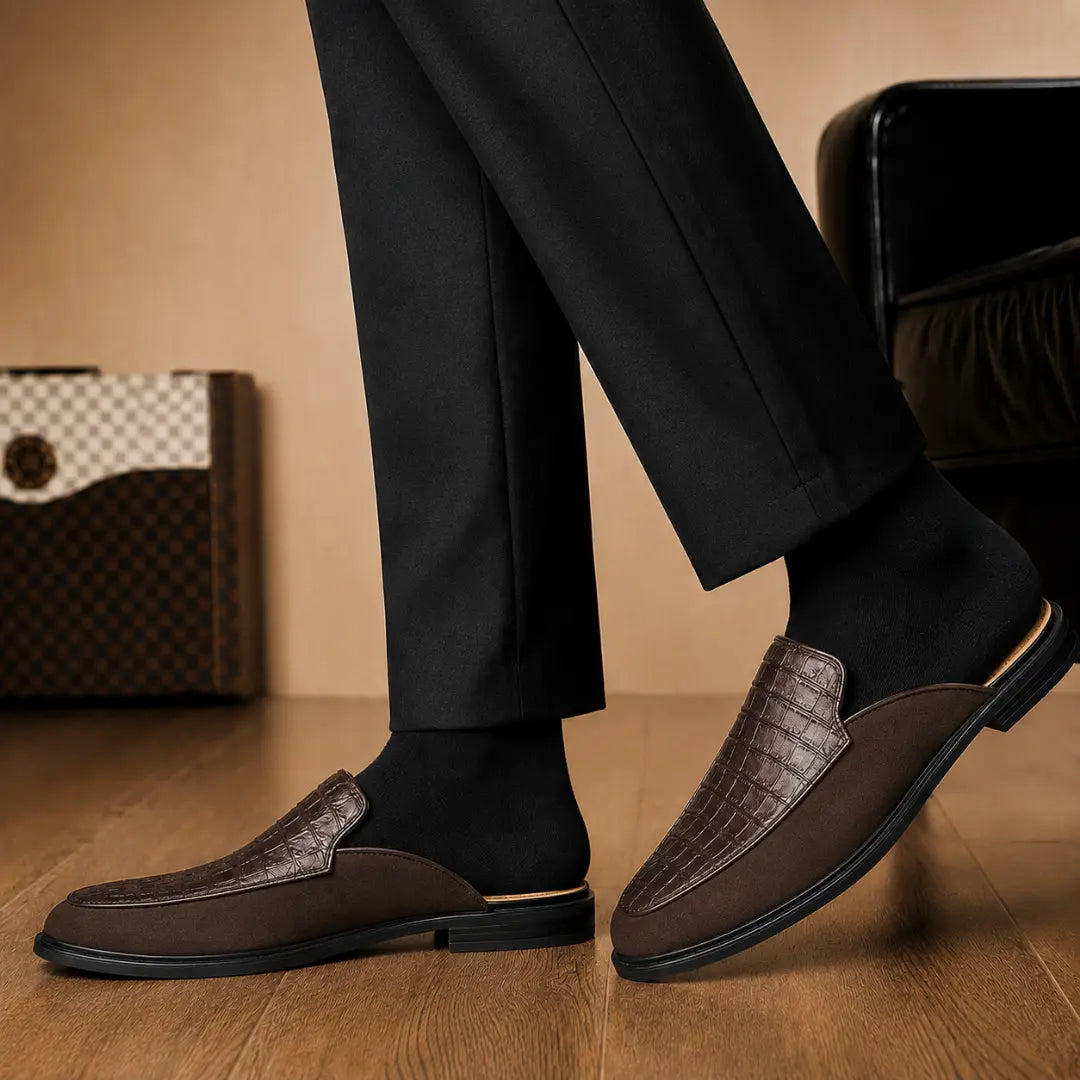 Melodiapelle Mckinsey Mule in dark brown croc-embossed leather worn with formal trousers, on-feet shot