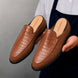 Man holding a pair of Melodiapelle Mckinsey Mule shoes in tan croc-embossed leather, close-up