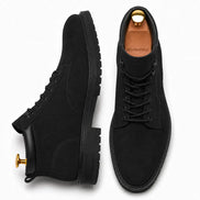 Black suede combat boot, three-quarter angle showing heel and sole detailing
