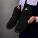 Man holding a pair of Melodiapelle Meilbourne Combat Boots in black suede, close-up