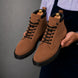 Man holding a pair of Melodiapelle Meilbourne Combat Boots in rust tan leather, close-up
