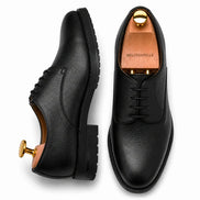 Black leather plain-toe Derby, three-quarter angle showing heel and sole detailing