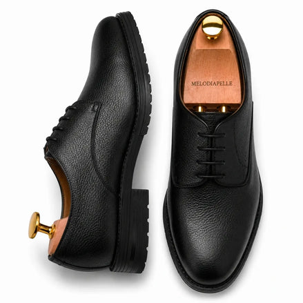 Black leather plain-toe Derby, three-quarter angle showing heel and sole detailing