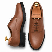 Tan leather plain-toe Derby, three-quarter angle showing heel and sole detailing