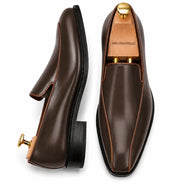 Brown leather dress loafer, three-quarter angle showing heel and trim detailing