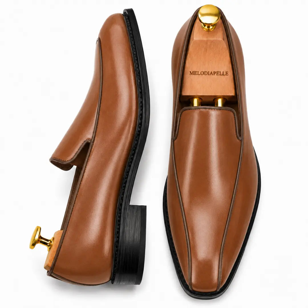 Tan leather dress loafer, three-quarter angle showing heel and trim detailing