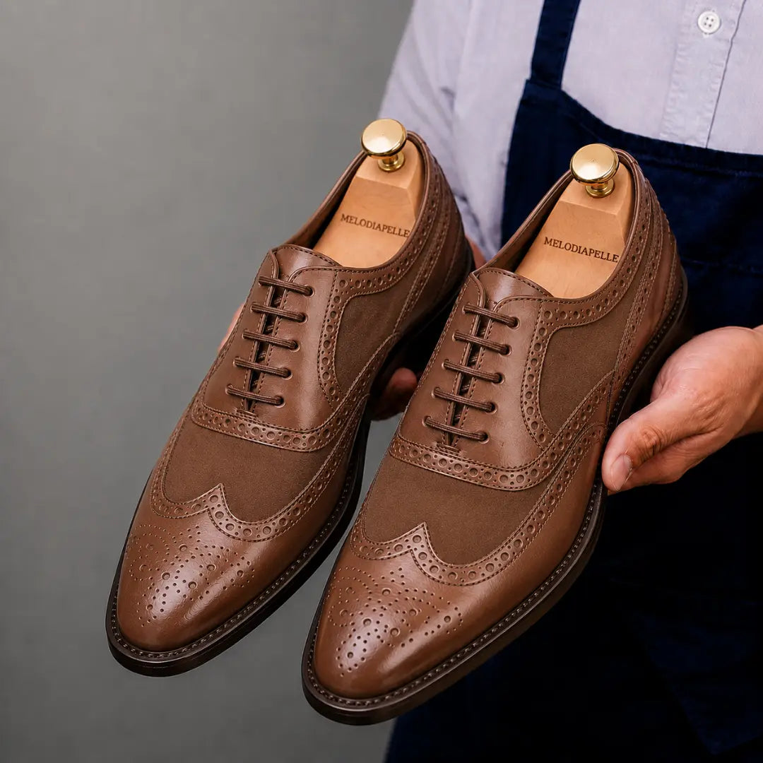 Man holding a pair of Melodiapelle Meta Semi-Brogue Oxford shoes in tan leather, close-up