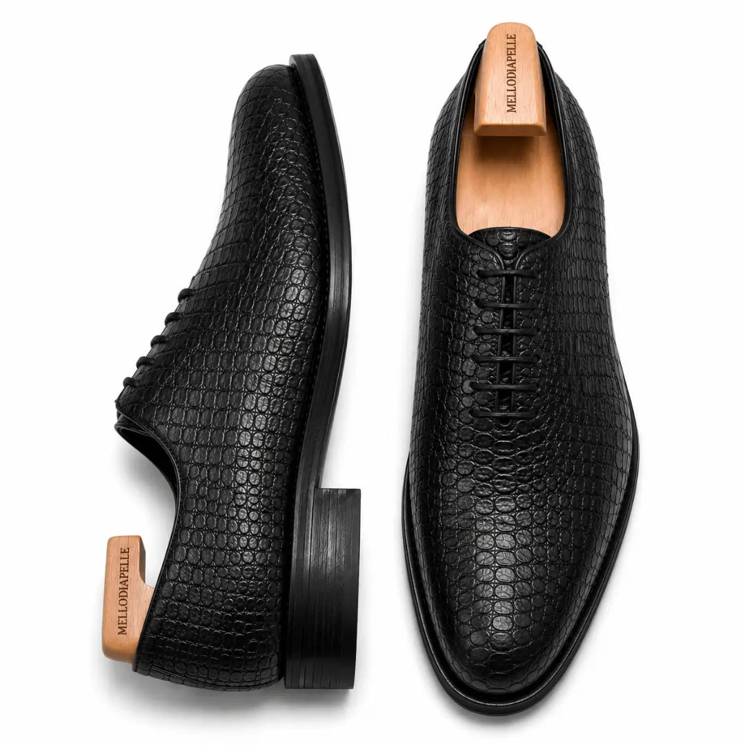 Black croc-embossed leather wholecut Oxford, three-quarter angle showing heel and texture detailing