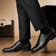 Melodiapelle Meta Wholecut Oxford in nero black leather worn with formal trousers, on-feet shot