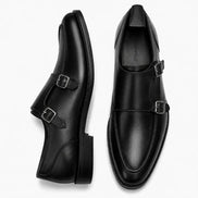 Black leather double monk strap shoe, three-quarter angle showing buckles and heel
