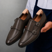 Man holding a pair of Melodiapelle Mexico Double Monk Strap shoes in brown leather, close-up
