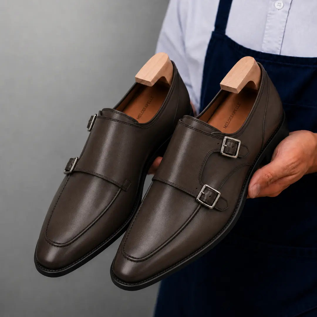 Man holding a pair of Melodiapelle Mexico Double Monk Strap shoes in brown leather, close-up