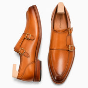 Honey tan burnished leather double monk strap shoe, three-quarter angle showing buckles and heel