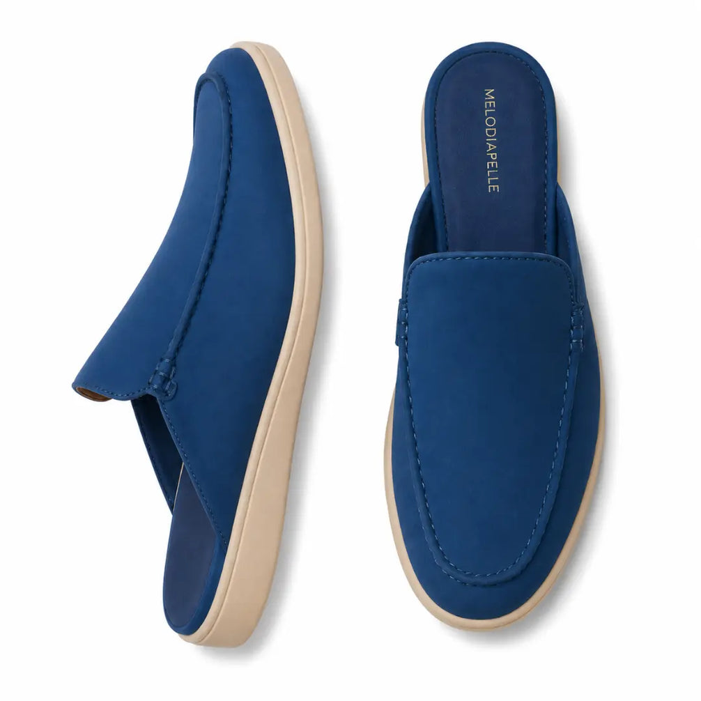 Royal blue suede backless mule, three-quarter angle showing heel and sole detailing