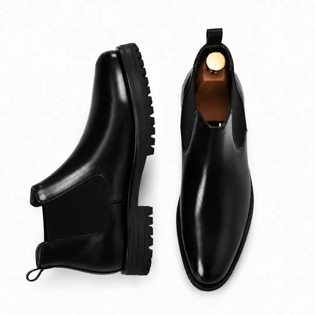 Black leather Chelsea boot, three-quarter angle showing heel and elastic side panel