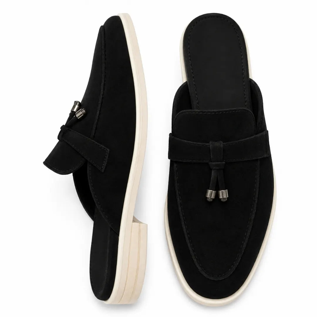 Black suede tassel mule, three-quarter angle showing tassel and sole detailing
