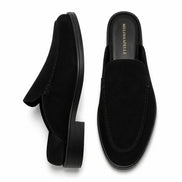 Black suede backless mule slipper, three-quarter angle showing heel and sole detailing