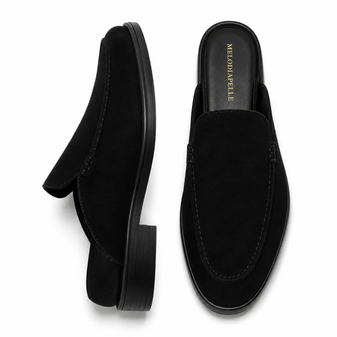 Black suede backless mule slipper, three-quarter angle showing heel and sole detailing